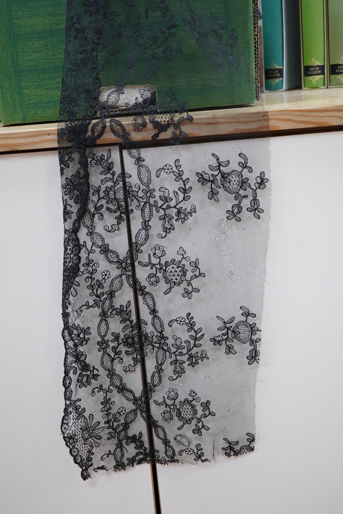 A collection of lace including black and coloured lace panels, mostly machine lace